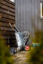 Wheel barrow stowed against a fence in a garden..