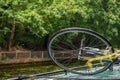 Wheelof a bicycle tied on the roof of a boat in a canal.