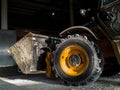 Wheel and Bucket of JCB loader in a warehouse of mineral organic fertilizers. Heavy Industrial Machinery working in a plant