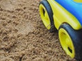 Wheel of car toy on sand background. Royalty Free Stock Photo