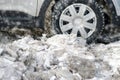The wheel of the car was stuck in pieces of ice and snow. Cleaning roa