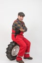 Wheel change mechanic sitting tiredly on a wheel Royalty Free Stock Photo