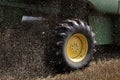 The wheel of a combine harvester in the movement of the harvested grain close up