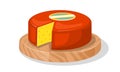 Wheel of delicious yellow holed cheese covered red wax is on round wood cutting board.