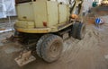 Wheel excavator machine unloading sand at eathmoving works in construction site. Old wheel excavator after work Royalty Free Stock Photo