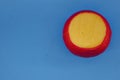 Wheel of fresh gouda cheese with a red rind on a blue monophonic background Royalty Free Stock Photo