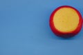 Wheel of fresh gouda cheese with a red rind on a blue monophonic background Royalty Free Stock Photo