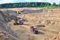 Wheel front-end loader loads sand into a dump truck. Heavy machinery in the mining quarry, excavators and trucks. Royalty Free Stock Photo