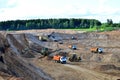 Wheel front-end loader loads sand into a dump truck. Heavy machinery in the mining quarry, excavators and trucks. Royalty Free Stock Photo