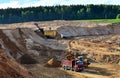 Wheel front-end loader loads sand into a dump truck. Heavy machinery in the mining quarry, excavators and trucks. Royalty Free Stock Photo