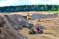 Wheel front-end loader loads sand into a dump truck. Heavy machinery in the mining quarry, excavators and trucks. Royalty Free Stock Photo