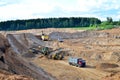 Wheel front-end loader loads sand into a dump truck. Heavy machinery in the mining quarry, excavators and trucks. Royalty Free Stock Photo