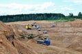 Wheel front-end loader loads sand into a dump truck. Heavy machinery in the mining quarry, excavators and trucks. Royalty Free Stock Photo