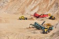 Wheel front-end loader loads sand into a dump truck. Heavy machinery in the mining quarry, excavators and trucks. Mobile jaw Royalty Free Stock Photo