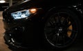 Wheel and lights of an exotic metallic black BMW M3 CS m power sports car