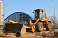 Wheel loader with a bucket on a street in the city during the construction of the road. Construction site with heavy machinery for