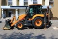 Wheel loader bulldozer with dirty bucket in town by building. Repair site