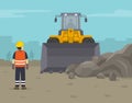 Wheel loader clearing the surface at earthmoving works in construction. The worker monitors the work process.