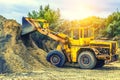 Wheel loader Excavator with backhoe loading sand at eathmoving works in construction site Royalty Free Stock Photo