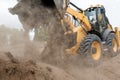 Wheel loader Excavator unloading sand and soil with dust Royalty Free Stock Photo