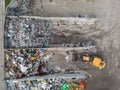 Wheel loader on the landfill site scooping and carrying waste, drone shot