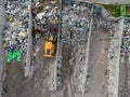 Wheel loader on the landfill site scooping and carrying waste, drone shot