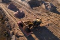 Wheel loader load the sand into dump truck in open pit. Developing the sand in the opencast. Heavy machinery on earthworks in Royalty Free Stock Photo