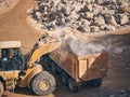 Wheel loader loads tipper with soil Royalty Free Stock Photo