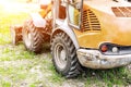 Wheel loader machine on grass field in park area. Municipal works on reconstruction and renewal city recreation area. Heavy and