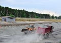 Wheel loader unload gravel and crushed stone in the dump truck. Unloading bulk cargo with of the cargo railway platform