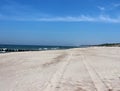 wheel marks on an empty sea beach in the first sunny days of summer, DziwnÃÂ³w, Poland Royalty Free Stock Photo