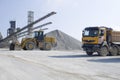 Wheel medium-sized Loader and belt conveyors and piles of rubble in Gravel Quarry Royalty Free Stock Photo