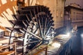 Wheel of an old watermill in the middle of Prague spinning at night with intentional motion blur