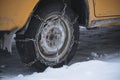 Wheel passenger car is clad in chains for driving on ice.