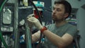 Wheel straightening stand in bicycle workshop. Mechanic uses tool to tension the spokes in rim of velocipede wheel