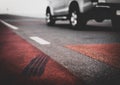 Wheel traces on the road with blurred car in background Royalty Free Stock Photo