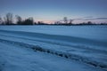 Wheel tracks on snow and snowdrifts on the field Royalty Free Stock Photo