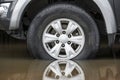 A wheel of a truck on a flooded road