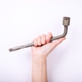 Wheel wrench in hand of the girl. Symbol of hard work, feminism and labor day. Isolate on white background Royalty Free Stock Photo