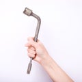 Wheel wrench in hand of the girl. Symbol of hard work, feminism and labor day. Isolate on white background Royalty Free Stock Photo