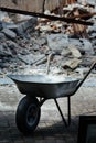 Wheelbarrow on the background of demolition of a garage - construction rubble