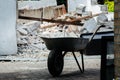 Wheelbarrow on the background of demolition of a garage - construction rubble