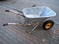 wheelbarrow is on the cobblestones. Construction accessory. Tool for transporting sand and cement. Construction and repair work