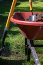 Wheelbarrow filled with dirt and a trowle