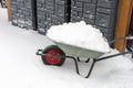 Wheelbarrow full of snow. Lots of snow on the sidewalk