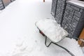 Wheelbarrow full of snow. Lots of snow on the sidewalk