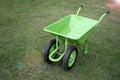 Wheelbarrow in the garden on the lawn. Green Wheelbarrow and the grass is cut in a garden Royalty Free Stock Photo