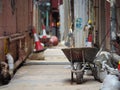 A wheelbarrow with some cement bags is in an alley Royalty Free Stock Photo