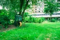 Wheelbarrow stands against a tree, Communal city garden