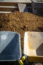 Wheelbarrows in front of a mountain of sand, ready to start work Royalty Free Stock Photo